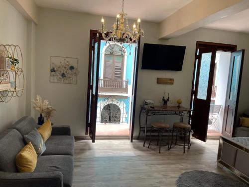 a living room with a couch and a chandelier at The Balconies Studio, The Marilyn Suite & The Crystal Apartment at Casa of Essence in Old San Juan in San Juan