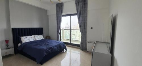 a bedroom with a bed and a large window at Stylish One bedroom with all amenities, close to downtown1 in Dubai
