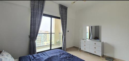 1 dormitorio con ventana y vestidor con espejo en Stylish One bedroom with all amenities, close to downtown1, en Dubái