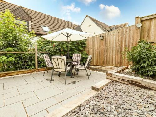 a patio with a table and chairs and an umbrella at Padstowgetaways in Padstow
