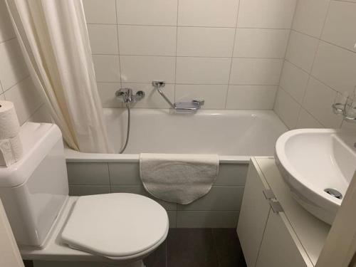 La salle de bains blanche est pourvue de toilettes et d'un lavabo. dans l'établissement Beautiful studio 2 minutes from the train station, à Lausanne