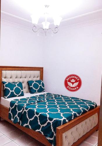 een slaapkamer met een bed met een blauw dekbed bij Residence Sighaka - Luxus VIP Apartment - WiFi, Gardien, Parking in Douala