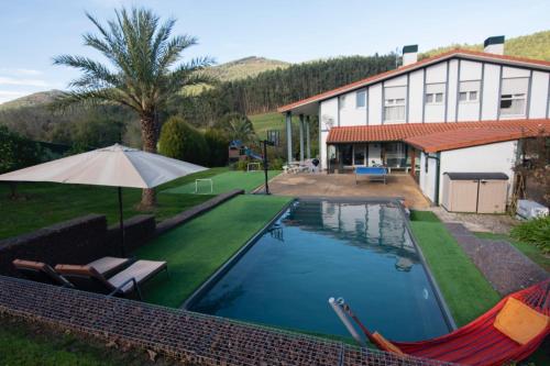 uma casa com piscina ao lado de uma casa em Casa Markaida Vizcaya em Munguía