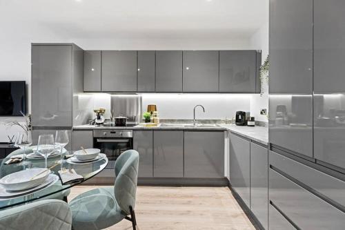 a kitchen with stainless steel appliances and a glass table at Private Modern Apartment in Olton