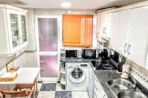 a small kitchen with a washing machine in it at Apartamento en la entrada del barrio antiguo in Córdoba