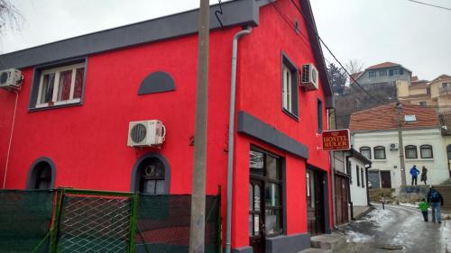a red building on the side of a street at Hostel Ruler in Belgrade