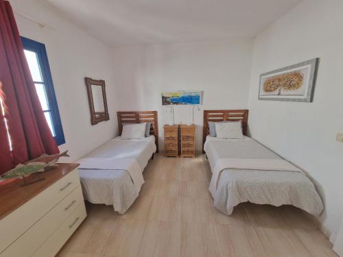 プラヤ・ブランカにあるVilla Danielaのベッド3台とドレッサーが備わる部屋
