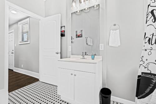 a white bathroom with a sink and a mirror at Lovely two-bedroom relaxing private parking Townhome rental in Detroit