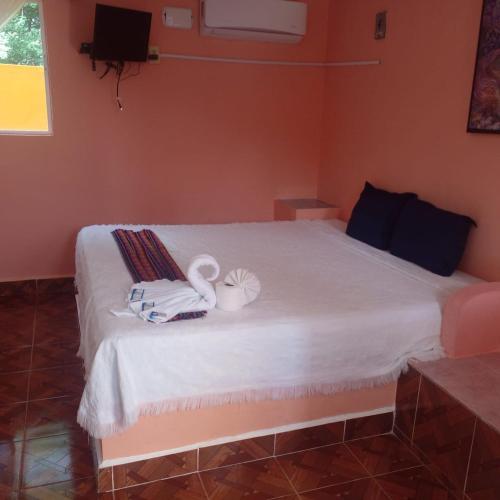 a bedroom with a bed with towels and swans on it at Motel Champoton sobre carretera frente al mar in Champotón