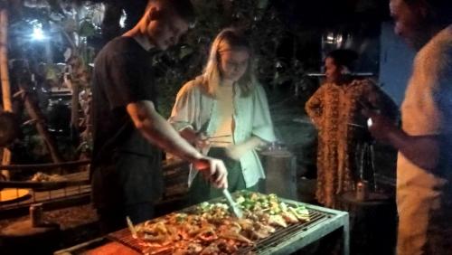 a group of people preparing food on a grill at Kakrona Pouk Homestay in Siem Reap