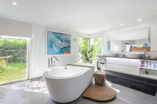 a white bathroom with a tub and two sinks at Villa Can Cozy in Ibiza Town
