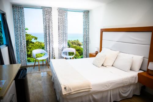 a bedroom with a bed and a large window at Serenity Rincon Guesthouse in Rincon