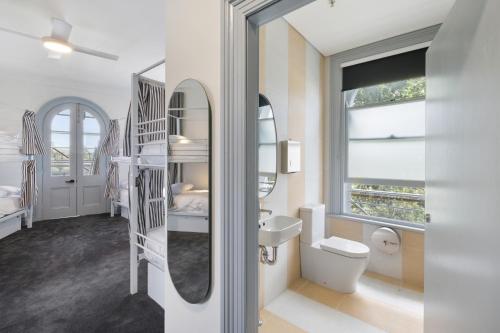 a bathroom with a sink and a toilet and a mirror at The Pacific House in Sydney