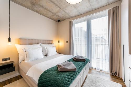 a bedroom with a bed and a large window at H75 Apartments Kosice Centre in Košice
