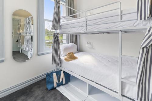 a bedroom with two bunk beds and a mirror at The Pacific House in Sydney