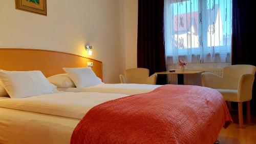 um quarto de hotel com duas camas e uma janela em Éva Panzió em Sárvár