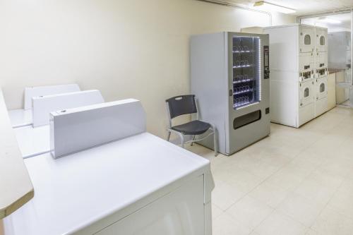 a white laboratory with a chair and a refrigerator at Baymont by Wyndham Laredo in Laredo