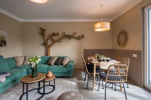 a living room with a green couch and a table at Balatonic Relax in Zamárdi