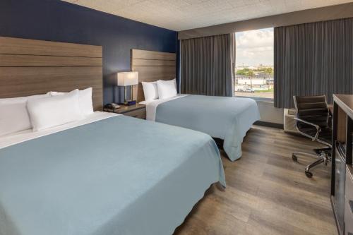 a hotel room with two beds and a window at Baymont by Wyndham Laredo in Laredo