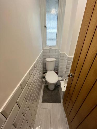 uma pequena casa de banho com um WC e uma janela em Archway Apartment em Londres