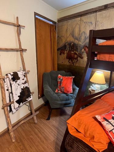 a room with a bed and a chair and a ladder at Acorn Hideaways Canton Old Western Ranch Hands' Suite in Canton