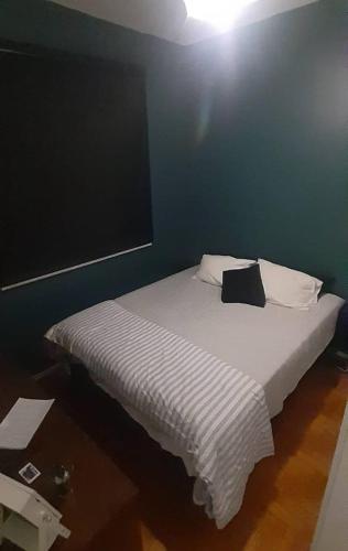 a bed in a room with a blue wall at Ap grande e ultramoderno e no ponto estratégico de Copacabana in Rio de Janeiro
