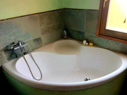 una vasca bianca in un bagno con finestra di Casa Gelsomino a Scandicci