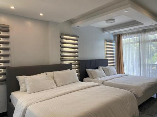 - une chambre avec 2 lits et une fenêtre dans l'établissement L’HYACINTH Hotel and Resort, à Potrero
