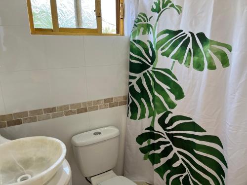 林孔孔德凱爾比斯的住宿－MonteMar Hotel y Bungalows，浴室设有卫生间和带叶子的浴帘。