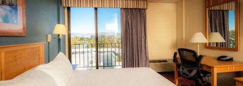 Habitación de hotel con cama, escritorio y ventana en The Federal Hotel Downtown Carson City, Ascend Hotel Collection, en Carson City