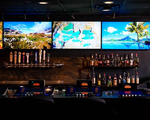 a bar with three televisions and bottles of alcohol at The Federal Hotel Downtown Carson City, an Ascend Collection Hotel in Carson City
