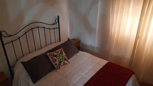 1 cama con almohada en el dormitorio en CONFORTABLE DEPARTAMENTO CÉNTRICO en Salta