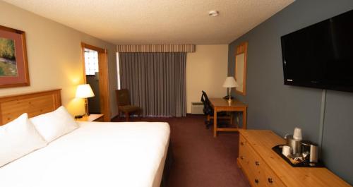 a hotel room with a bed and a flat screen tv at The Federal Hotel Downtown Carson City, an Ascend Collection Hotel in Carson City