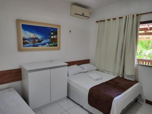 ein kleines Schlafzimmer mit einem Bett und einem Fenster in der Unterkunft Linda casa 4/4 com piscina na Praia do Forte. in Mata de Sao Joao