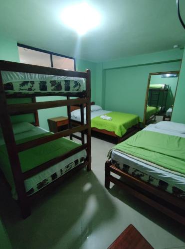 1 dormitorio con 2 literas y espejo en Hostal BAMBU, en Tena