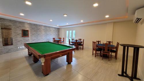 a room with a pool table and some tables and chairs at Golden Arraial RJ enter o Mar e a Lagoa Piscina e Wi-Fi in Arraial do Cabo