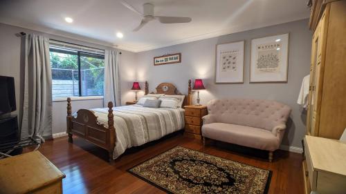 a bedroom with a bed and a chair and a window at Frostwood House in Mount Barker