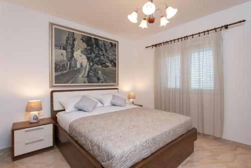 a bedroom with a bed and a painting on the wall at Holiday Villa Natura in Orebić