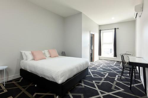 a bedroom with a bed and a desk in it at Sports Garden Hotel in Launceston