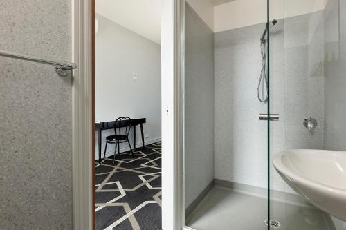 La salle de bains est pourvue d'un lavabo et d'une douche. dans l'établissement Sports Garden Hotel, à Launceston