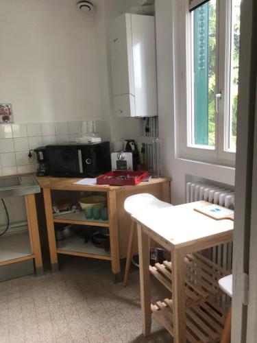 una pequeña cocina con mesa y microondas en Appartement paisible proche centre ville, en Villennes-sur-Seine