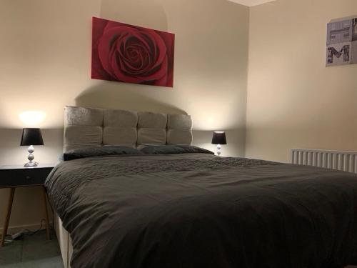 a bedroom with a large bed with a red painting on the wall at One Bedroom Apartment Near QMC & University of Nottingham in Nottingham