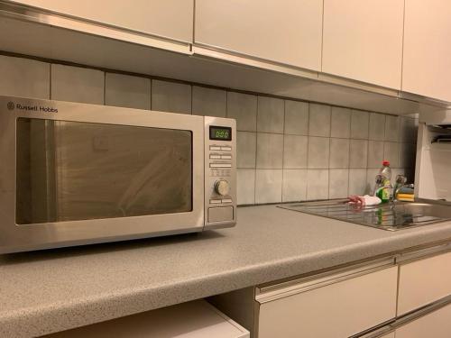 a microwave oven sitting on a counter in a kitchen at One Bedroom Apartment Near QMC & University of Nottingham in Nottingham