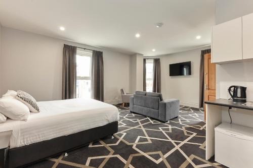 Habitación de hotel con cama y silla en Sports Garden Hotel en Launceston