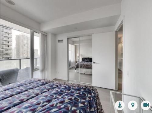 a bedroom with a large bed and a large window at Comfortable Central Downtown Condo - in Toronto