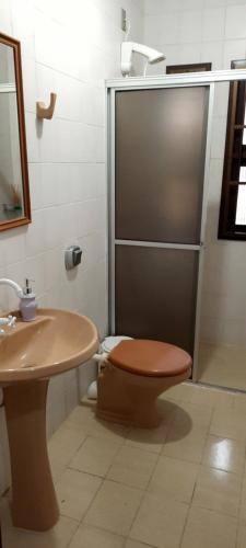 a bathroom with a toilet and a sink at Casa agradável, ampla com estacionamento in Tramandaí