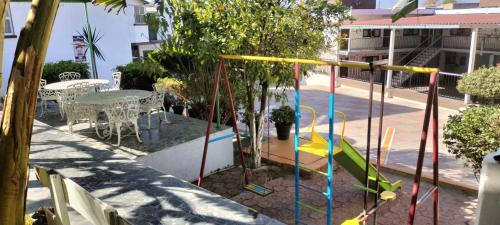 a playground with a slide and a table and chairs at Hotel Avenida Ixmiquilpan in Ixmiquilpan