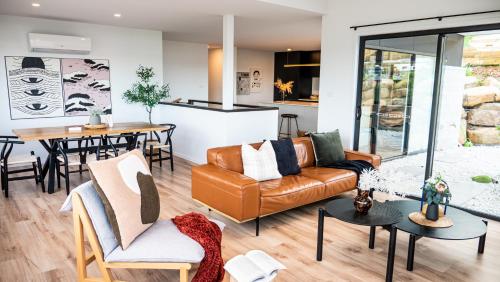 a living room with a couch and a table at Amazing view Architech Home 8Minutes to Hobart CBD in Hobart