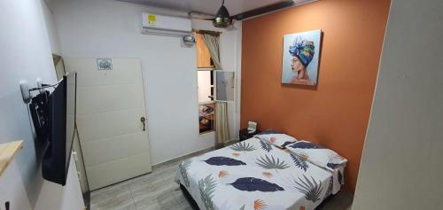 1 dormitorio con 1 cama y una pintura en la pared en Como en casa, en La Dorada