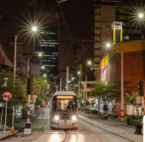 a train traveling down a city street at night at Piso13 Sabaneta, apartment, Parking, Pool & with club in the sky! in Sabaneta